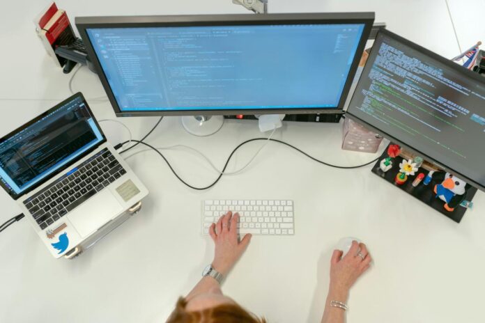 Orang yang menggunakan MacBook Pro di meja putih